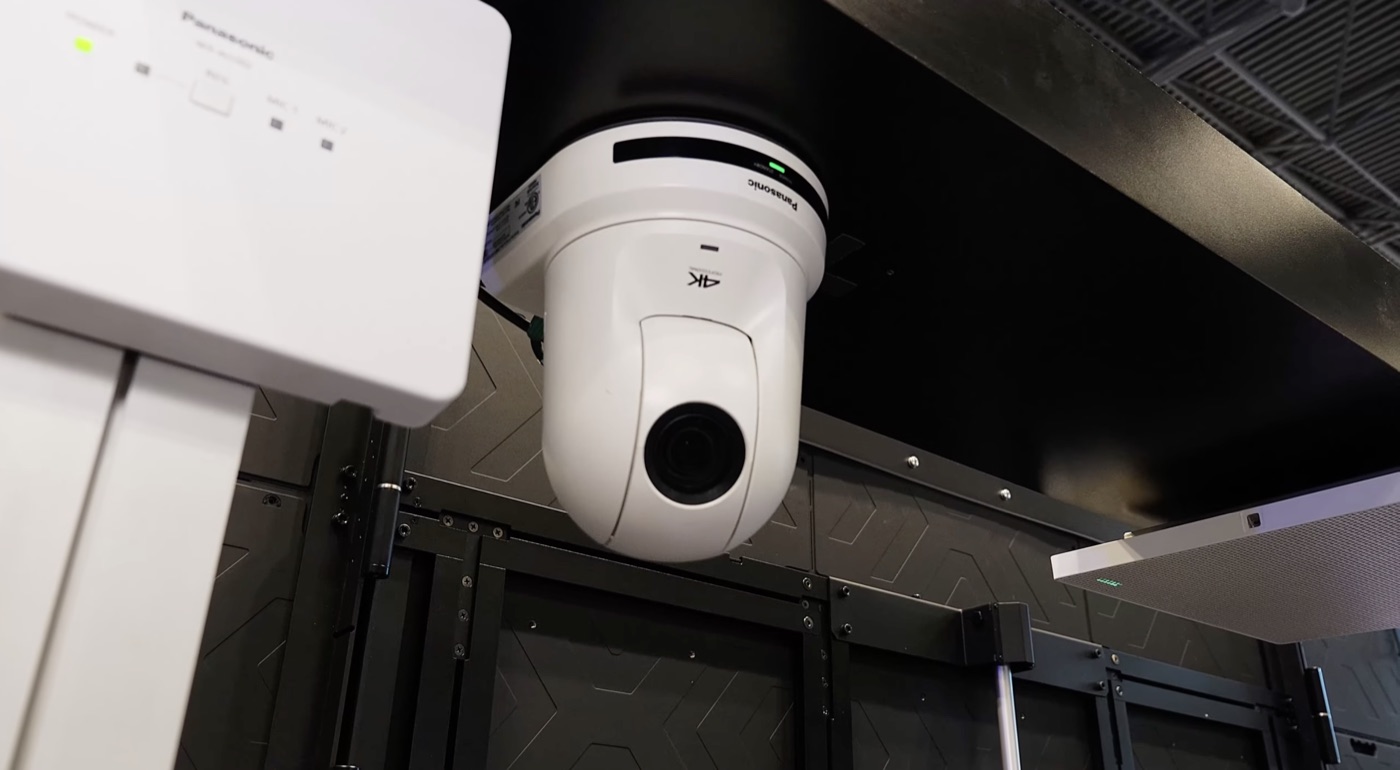 Cámara PTZ 4K instalada en techo, junto al equipo de sala